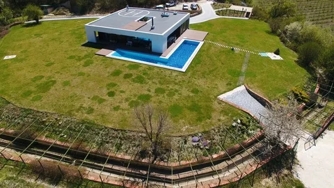 Villa with pool in mountains. Man doing workout on roof of house. Aerial view Stock Footage 129792785