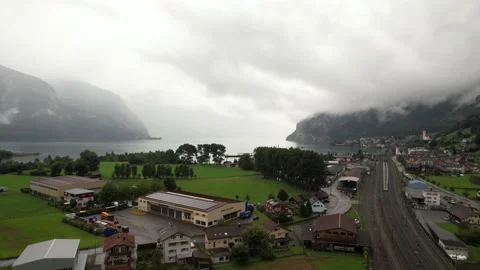 Village in Alpine Valley Under Clouds | Drone Over European Mountains Stock Footage 194567562