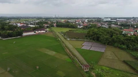 Village on the edge of rice fields with cloudy skies from drone angle Stock-Footage 278962263