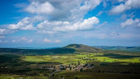 Village Nestled Under Patchy Cloud Shadows in Mountain Valley Foto stock