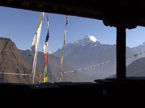 Villagers walk past prayer flags with Himalayas in background Stock Footage 86748834