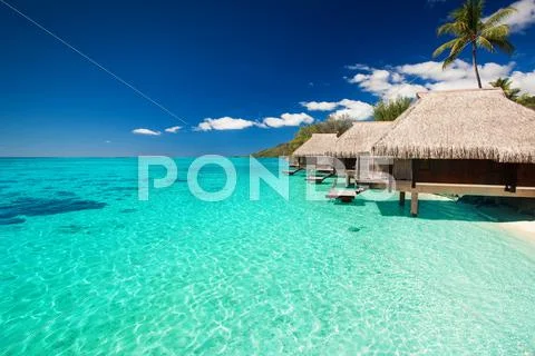 Villas on the tropical beach with steps into water Stock Photos
