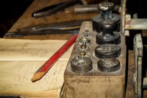Vinatge desk with ancient weights, notes and old pencil Stock Photos