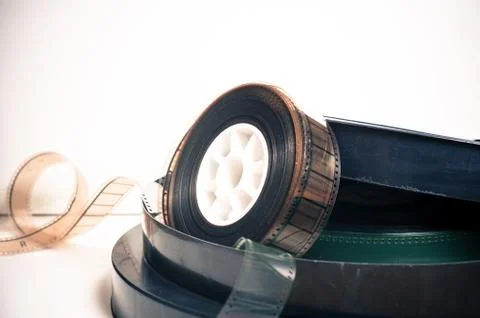 Movie clapper and vintage 35 mm film cinema reel on white Stock
