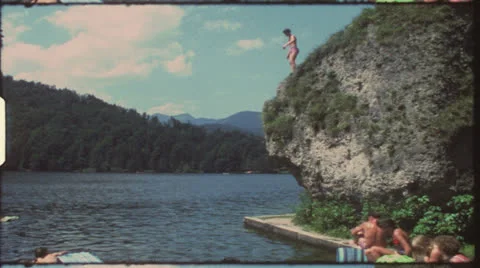 Vintage 8 mm film: Children jumping in lake, 1970s Stock Footage