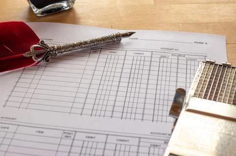 Vintage adding machine on ledger accounting page with feather quill and ink p 写真素材