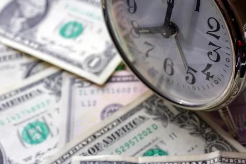 Vintage alarm clock on one dollar bills. Stock Photos