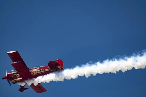 Vintage biplane does loop stunt with smoke trails. airplane air show Stock Photos