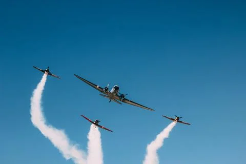 Vintage biplane does loop stunt with smoke trails. Stock Photos
