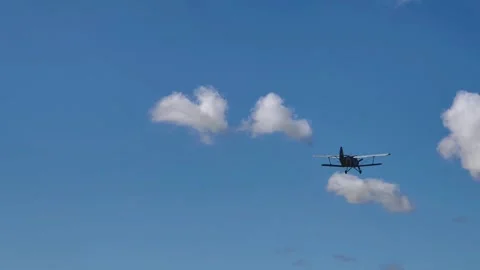 Vintage Biplane Soaring Through Blue Sky With Dramatic Clouds Stockbeeldmateriaal 345060080