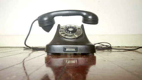 Vintage black phone ringing slow then fast on an old wooden Stock Footage