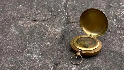 Vintage brass compass on stone surface Stock Photos