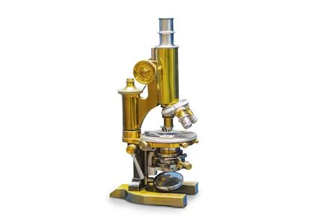 Vintage brass microscope on white surface in a pharmacy antique cabinet a Stock Photos