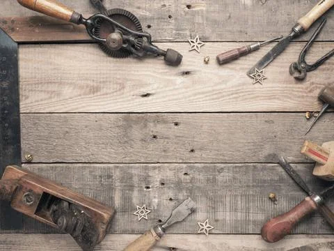 Vintage carpenter tools as a frame on a rustic wooden workbench with space... Stock Photos