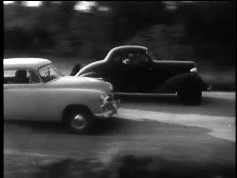 Vintage cars racing and kicking up dust on country road, 1960s Stock Footage