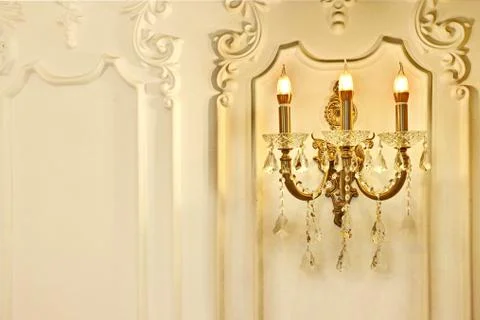 Vintage chandelier sconce lamp with candle lights on light wall Stock Photos