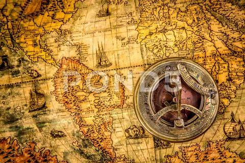 Vintage compass lies on an ancient world map Stock Photos