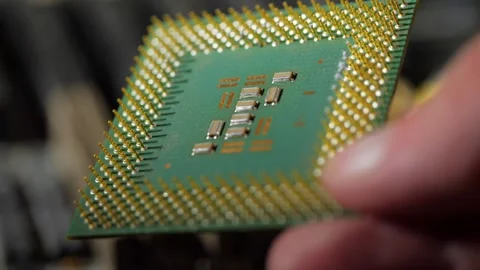 Vintage computer microprocessor is held by a man's hand on a background of compu Stock Footage 283442755