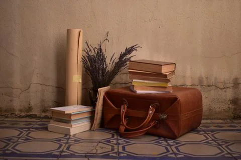 Vintage concept: Stack of old books, lavender, guitar, old suitcase Stock Photos