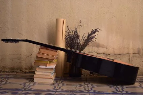 Vintage concept: Stack of old books, lavender, guitar, old suitcase Stock Photos