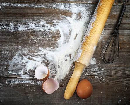 Vintage cooking background Eggs, eggshells, flour and rolling pin on woode... Stock Photos