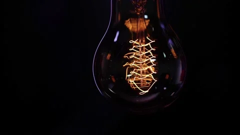 A vintage decorative light bulb shines in the dark close up. Stock Footage 149196013