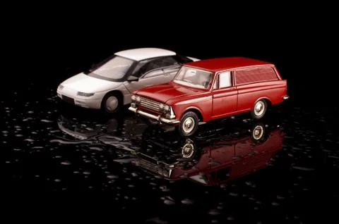 Vintage die-cast plastic and metal model cars on the black reflective backgro 스톡 사진