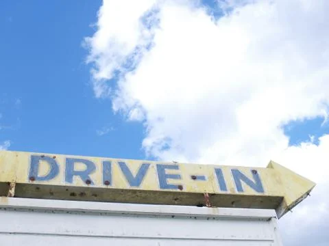 Vintage Drive-in Theater sign with arrow and summer sky Stock Photos