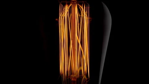 Vintage Edison light bulb with orange filament spiral light on black backgr.. Stock Footage 296152953