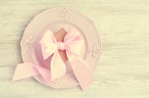 Vintage festive table setting top view. Pink bow on plate on light background Stock Photos