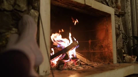 Vintage fireplace. General plan of a retro wood burning stove. Feet in socks are Stock Footage 302354069