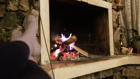 Vintage fireplace. General plan of a retro wood burning stove. Feet in socks are Stock Footage 302354071