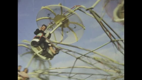 Vintage funfair ride spinning with passengers in the 1950s Stock Footage 309450669