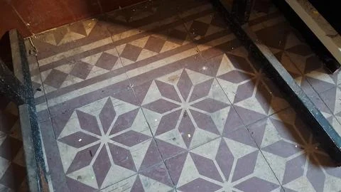 Vintage geometric patterned ceramic floor tiles with warm natural lighting Foto stock