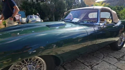 Vintage green Jaguar E-Type convertible displayed at Malta Classics in Villa Video stock 325365926