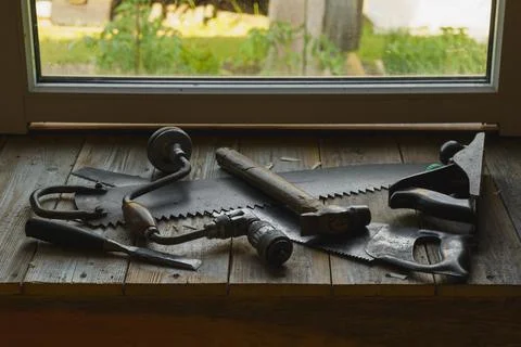 Vintage hacksaw, jointer, chisel, hammer and drill are in workshop by the window 스톡 사진