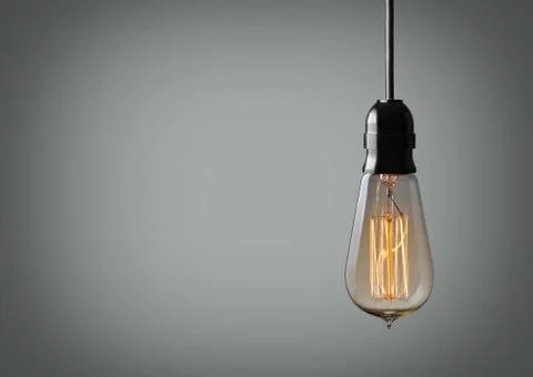 Vintage hanging light bulb over gray background Stock Photos