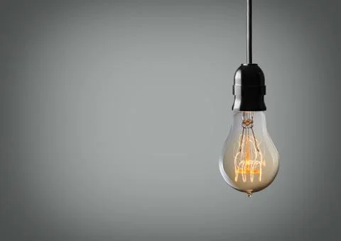 Vintage hanging light bulb over gray background Stock Photos