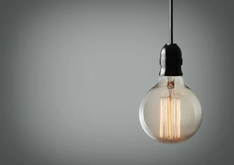 Vintage hanging light bulb over gray background Stock Photos