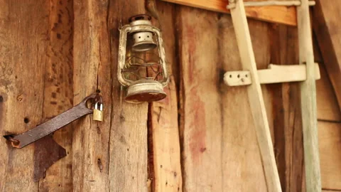 Vintage Kerosene Lamp Hanging on Rustic Wooden Wall with Padlock Stock Footage 304587147