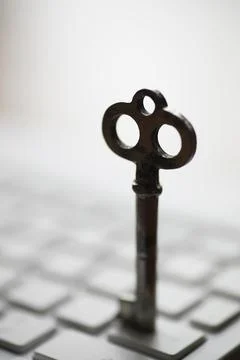 Vintage Key on Computer Keyboard Symbolizing Cyber Security and Digital Acces Stock Photos