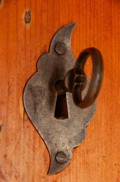 A vintage key in an old, rustic wrought iron keyhole Stock Photos