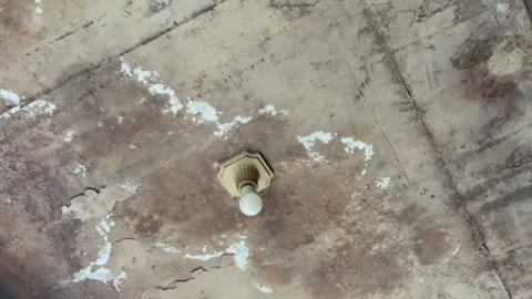 Vintage light bulb mounted on rustic damaged concrete ceiling 스톡 동영상 341897394