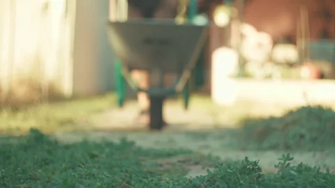 Vintage low angle pushing wheelbarrow from out of focus into sharp focus in a Stock Footage 342832019