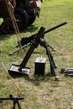 Vintage machine gun and an array of other firearms in an outdoor setting 스톡 사진