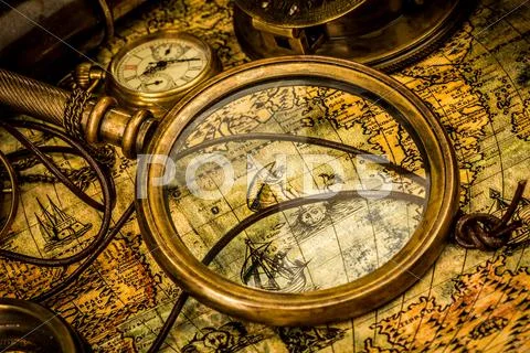 Vintage magnifying glass lies on an ancient world map Stock Photos