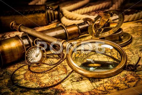 Vintage magnifying glass lies on an ancient world map Stock Photos