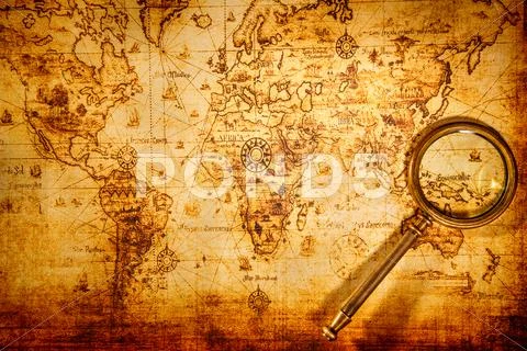Vintage magnifying glass lies on an ancient world map Stock Photos