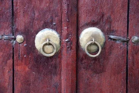 Vintage metal knobs with a ring on an old wooden door close-up Fotos de archivo