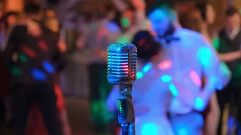 Vintage microphone against the background of dancing people. Nightclub. Disco. Stock Footage 132248740